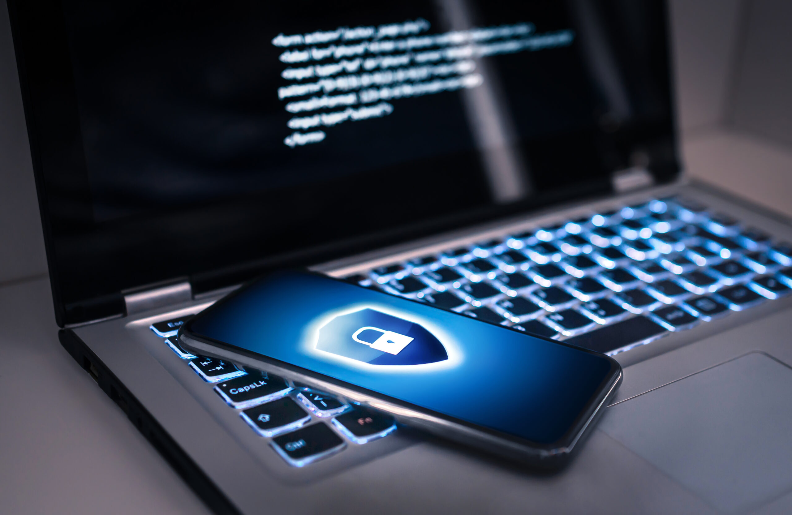 Phone lock to protect from cyber scam, online data fraud or identity theft. Laptop with hacker virus code in screen. Phishing, cybersecurity danger or ransomware attack. finger pressing against table with stars and lock in background